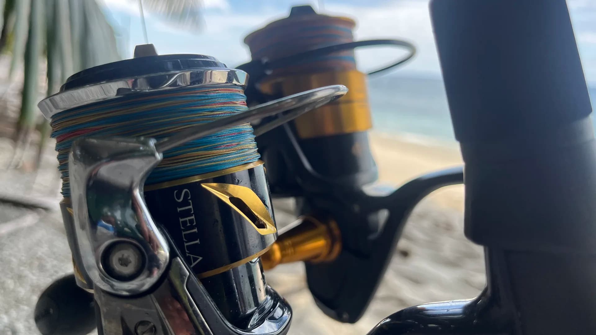 Moulinets de pêche haut de gamme montés sur cannes face à une plage du Pacifique panaméen